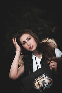 Portrait of woman with backpack standing in forest