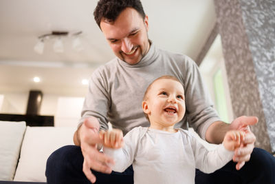 Cheerful son with father at home