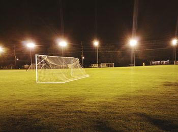 Soccer field against sky at night