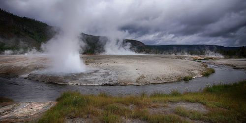 Scenic view of hot springs against cloudy sky