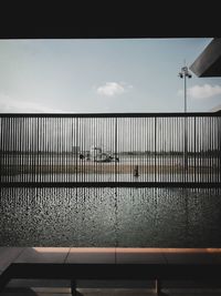 Airplane at runway seen through fence