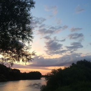 Scenic view of river against cloudy sky