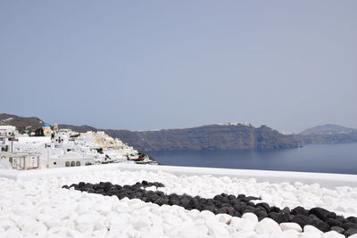 Scenic view of sea by buildings against clear sky