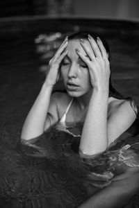 High angle view of young woman sitting on swimming pool 