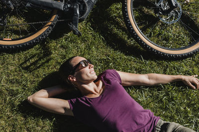 Portrait of young woman lying on field