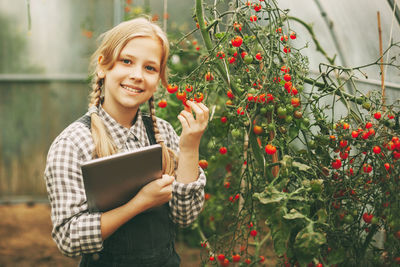 Portrait of a smiling young woman holding plant