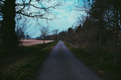 View of country road passing through field