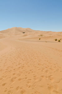 Scenic view of desert against clear blue sky