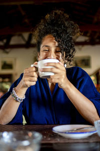 Relaxed woman smiling and drinking a cup of coffee