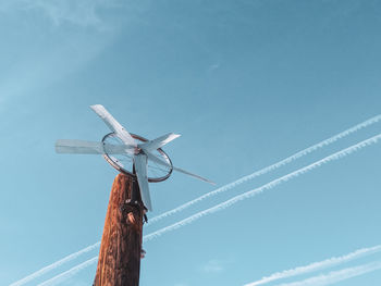 Low angle view of windmill against blue sky