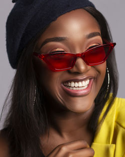 Close-up of smiling young woman wearing sunglasses