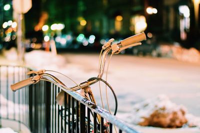 Bicycle parked by railing on street