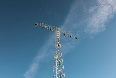 Low angle view of electricity pylon against sky