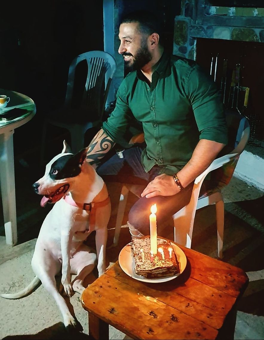real people, one person, domestic animals, domestic, pets, one animal, candle, mammal, flame, casual clothing, burning, fire, sitting, lifestyles, dog, front view, vertebrate, birthday candles