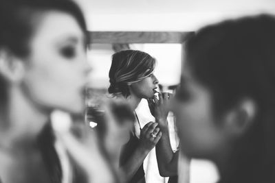 Artist applying make-up on bride