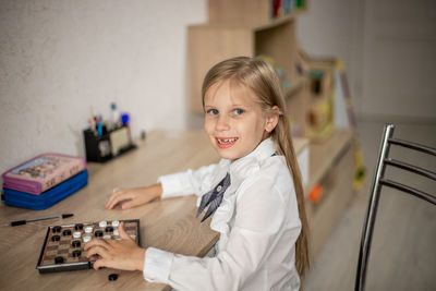 Portrait of cute girl playing with toy at home