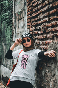 Full length of boy wearing sunglasses standing against wall