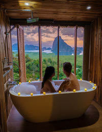 Rear view of woman swimming in bathtub