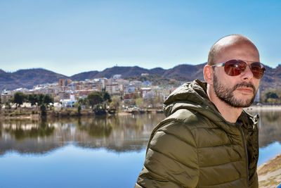 Portrait of man with sunglasses standing against clear sky