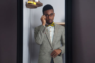 Young man standing against wall