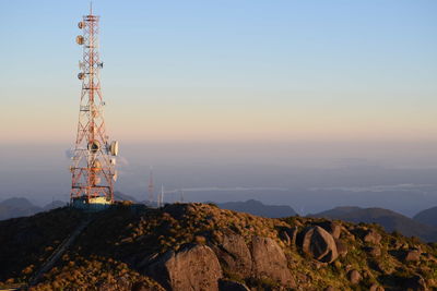 Low angle view of communications tower against sky during sunset