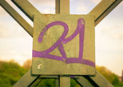 The number 21 graffitied on a section of an iron bridge.