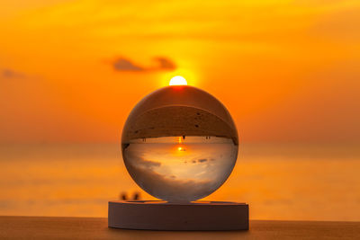 Close-up of sea against orange sky