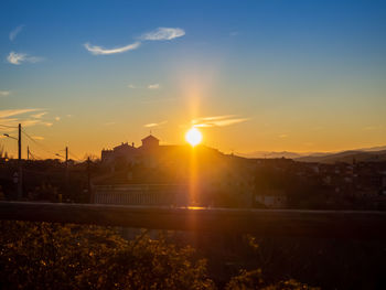 Silhouette buildings against sky during sunset