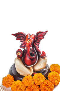 Close-up of red statue against white background