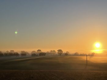 Scenic view of field against sky during sunset