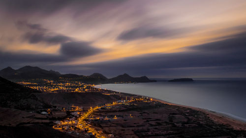 High angle view of illuminated town against the river