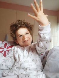 Portrait of smiling girl on bed at home