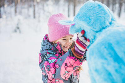 Father wearing costume with daughter on snowy field