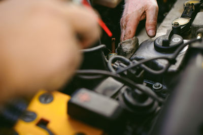 Cropped hands of mechanic repairing engine