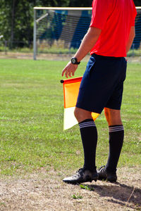 Low section of soccer player with flag standing on field