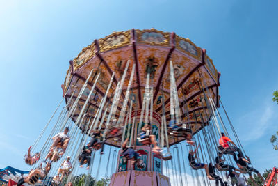 Low angle view of people on amusement park ride