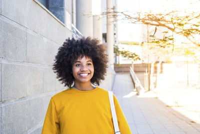 Portrait of woman standing against wall