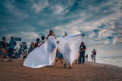 People on beach against sky