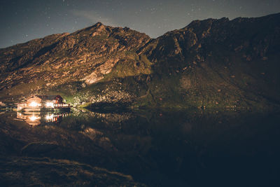 Cars on mountain against sky at night