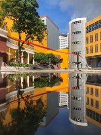 Reflection of building in city against sky