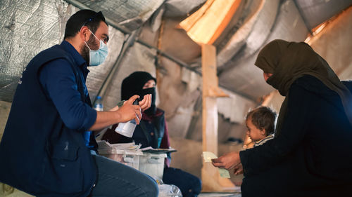  a doctor explains to refugees how to prevent a cholera epidemic.