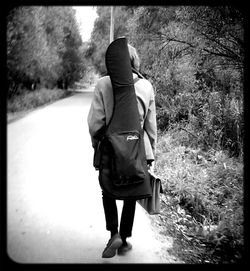 Rear view of woman standing by tree