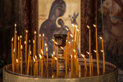 Close-up of illuminated candles in temple