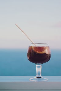 Close-up of drink on table against sea