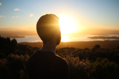 Low section of silhouette person against sky during sunset