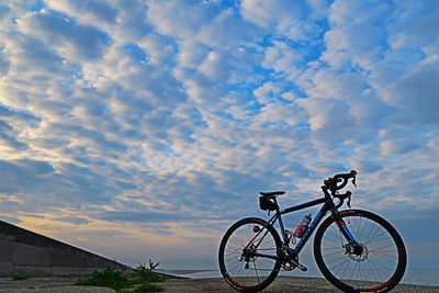 Bicycle against sky during sunset
