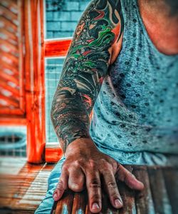 Midsection of man with arms outstretched standing outdoors