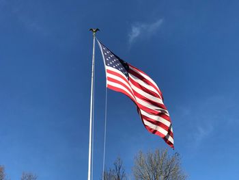 Low angle view of flag against blue sky