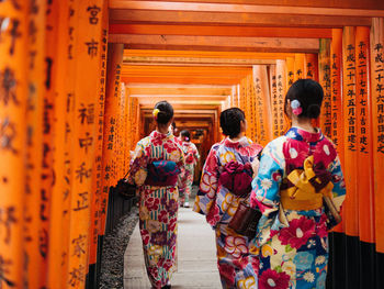 Rear view of friends standing outside temple
