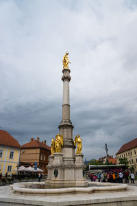 Holy mary column amidst town against cloudy sky in croatia